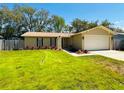 Lovely single-story home with a well-manicured lawn and mature trees in a peaceful setting at 10320 White Cedar St, Port Richey, FL 34668