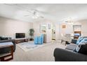 Relaxing living room with plush couches, a ceiling fan, and an open view to the dining and kitchen areas at 11719 Boynton Lane, New Port Richey, FL 34654