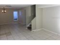 Spacious living room featuring tile flooring, neutral walls, and a staircase leading to the second floor at 12611 Touchton Dr # 122, Tampa, FL 33617