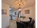 Cozy dining area featuring a modern chandelier and views into the updated kitchen at 1312 Tuscola St, Clearwater, FL 33756
