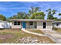 Charming single-story home with a blue front door, well-maintained lawn, and inviting curb appeal at 1312 Tuscola St, Clearwater, FL 33756