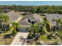 Aerial view of a lovely home with mature palm trees and a water view at 1647 Emerald Dunes Dr, Sun City Center, FL 33573
