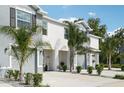 Inviting townhome with a one-car garage, neutral color scheme, and lush tropical landscaping at 16646 Maude Dr, Wimauma, FL 33598