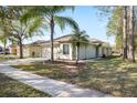 A single-story home with a well-manicured lawn and tropical landscaping at 18152 Portside St, Tampa, FL 33647