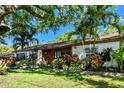 A charming single-story home featuring lush landscaping with vibrant plants and a well-manicured lawn at 18846 Tracer Dr, Lutz, FL 33549