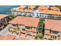 An aerial view shows the luxurious townhome community with red tile roofs and lush landscaping at 254 Seagate Ct, Dunedin, FL 34698
