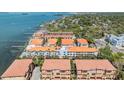 An aerial view shows the waterfront community with tropical landscaping and stunning bay views at 254 Seagate Ct, Dunedin, FL 34698