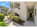 Exterior view of a condo building with well maintained landscaping, a sidewalk and access to the units at 2650 Countryside Blvd # B102, Clearwater, FL 33761