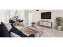 Bright living room with a dining area, plush sofa, modern decor, and tile flooring at 2650 Countryside Blvd # B102, Clearwater, FL 33761