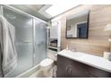 Updated bathroom featuring a shower, vanity with modern finishes, and unique shiplap accent wall at 3219 Spanish Moss Ln, Palm Harbor, FL 34684