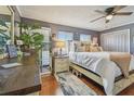 Comfortable bedroom with hardwood floors, neutral paint, ceiling fan, and ample natural light at 3632 Pine Cone Cir, Clearwater, FL 33760