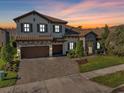 Elegant two-story home with a tile roof, stone accents, manicured lawn, and a brick-paved driveway at 4681 Night Star Trl, Odessa, FL 33556