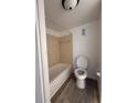 Tiled bathtub and toilet in a bathroom with wood-look flooring and updated fixtures at 7529 Pitch Pine Cir # 190, Tampa, FL 33617