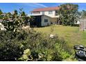 Spacious backyard featuring a lush lawn, mature trees, and a covered patio for relaxing and entertaining at 842 180Th E Ave, Redington Shores, FL 33708