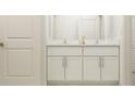Bathroom vanity featuring double sinks and white cabinets and marble countertops at 8429 Sea Ray Run, Parrish, FL 34219