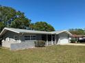 A gray single-story home with neutral trim, well-kept lawn, and mature trees providing shade and curb appeal at 10126 Bahama Ct, Seminole, FL 33776