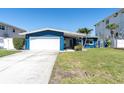 Exterior shot of a well maintained blue home with a green lawn at 11125 7Th E St, Treasure Island, FL 33706