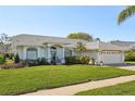 Well maintained one-story home with lush green lawn, manicured landscaping, and inviting front entrance at 13553 Landers Dr, Hudson, FL 34667