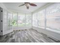 Bright sunroom features wood tile flooring, large windows, and serene views at 1807 23Rd N Ave, St Petersburg, FL 33713
