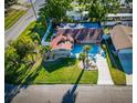 Bird's-eye view of the home featuring lush landscaping, a fenced backyard, and a spacious driveway at 2096 Church Creek Pt, Largo, FL 33774