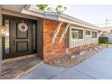 Inviting entryway with a decorative wreath on the front door, complemented by brick accents and stone walkway at 2096 Church Creek Pt, Largo, FL 33774