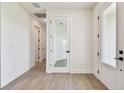 Hallway with plank flooring, white walls, white doors and black hardware at 2832 Marrakesh Ln, Sarasota, FL 34234