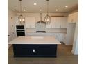 Bright kitchen with modern stainless steel appliances, large island and pendant lighting at 2832 Marrakesh Ln, Sarasota, FL 34234