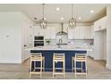 Bright kitchen features a center island with counter seating, white cabinetry, and modern pendant lighting at 2832 Marrakesh Ln, Sarasota, FL 34234