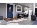 Inviting front porch with a blue door, two chairs, and decorative accents for a welcoming atmosphere at 314 E Althea Ave, Tampa, FL 33612