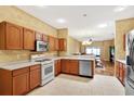Bright kitchen showcasing wood cabinets, white countertops, stainless steel appliances and views to the dining area at 31833 Turkeyhill Dr, Wesley Chapel, FL 33543