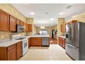 Open-concept kitchen featuring wood cabinets, white countertops, stainless steel appliances, and seamless transition to the dining area at 31833 Turkeyhill Dr, Wesley Chapel, FL 33543