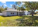 Front elevation of updated home with palm trees, well kept grass, and updated features at 3352 Honeymoon Ln, Holiday, FL 34691