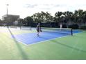 Active pickleball game on a well-maintained court surrounded by lush greenery at 4594 Mohican Trl # 143, Sarasota, FL 34233