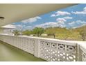 Balcony view with the breeze block wall and blue sky with trees in the distance at 4885 1St Ne St # 305, St Petersburg, FL 33703