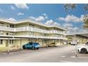 This is a view of the condo's exterior with covered parking with several cars in the distance at 4885 1St Ne St # 305, St Petersburg, FL 33703