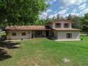 Attractive stucco home with a large front yard and mature trees creating a serene setting at 4902 Five Acre Rd, Plant City, FL 33565