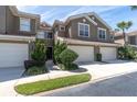 Well-maintained townhome exterior with a private entrance, two-car garage, and fresh landscaping at 4965 Anniston Cir, Tampa, FL 33647