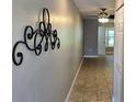 Long hallway with tile floors, decorative wall art, leading to a naturally lit room at 5725 80Th N St # 107, St Petersburg, FL 33709