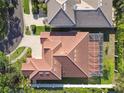 Aerial view of a home showcasing a terracotta roof and a screened-in porch, surrounded by green grass at 601 Viento De Avila, Tampa, FL 33613