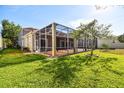 Spacious backyard featuring a screened-in porch and lush green grass, perfect for outdoor relaxation at 601 Viento De Avila, Tampa, FL 33613
