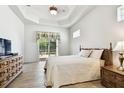 Bright bedroom featuring wood-look tile floors, neutral walls, and a sliding glass door with outdoor access at 601 Viento De Avila, Tampa, FL 33613