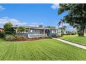 Charming single-story home featuring a well-maintained lawn, inviting front porch, and vibrant landscaping with a brick walkway at 6727 Burlington N Ave, St Petersburg, FL 33710