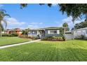 Charming single-story home featuring a well-maintained lawn, inviting front porch, and vibrant landscaping with a brick walkway at 6727 Burlington N Ave, St Petersburg, FL 33710