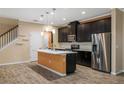 Modern kitchen featuring dark cabinets, stainless steel appliances, and a central island with a light countertop at 6732 Rocky Park St, Tampa, FL 33625