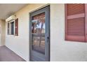 Close-up of the front door showing its design and hardware of the condo unit with a window at 8711 Blind Pass Rd # 207A, St Petersburg, FL 33706