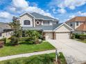 Charming two-story home with manicured lawn and stone accents on a sunny day with a clear blue sky at 10220 Deercliff Dr, Tampa, FL 33647