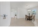 Bright dining room featuring tile floors and a modern chandelier above a glass table at 1050 Davis Heather Cir, Seffner, FL 33584
