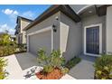 Attached two-car garage with a gray door and well-maintained landscaping at 1050 Davis Heather Cir, Seffner, FL 33584