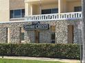 Close-up view of Shore Crest signage on stone wall, with a hedge, and a street sign at 1200 N Shore Ne Dr # 212, St Petersburg, FL 33701