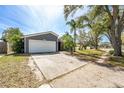 Single Gathering home features an attached garage, a wide driveway, and mature shade trees at 1366 Wexford N Dr, Palm Harbor, FL 34683